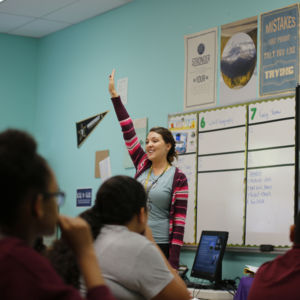Teacher demonstrating to class how to be called on by raising hand