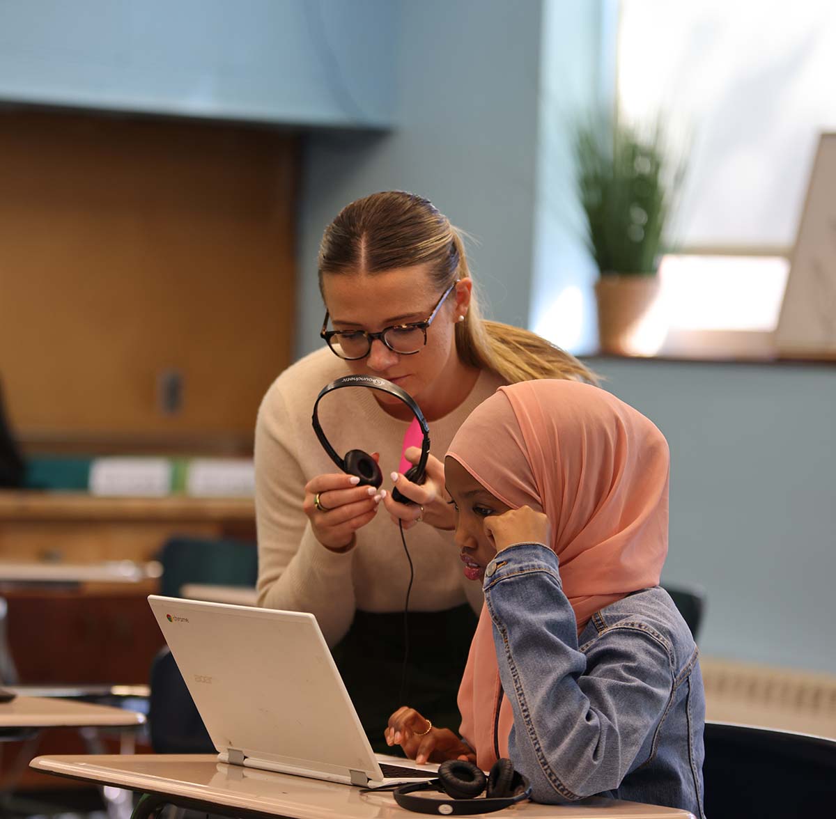 HSA Twin Cities Teacher and student interacting at a classroom desk